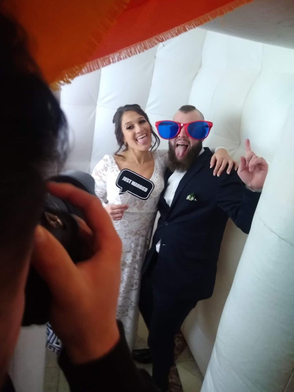 Personas en un casamiento sacándose una foto en la cabina de fotos